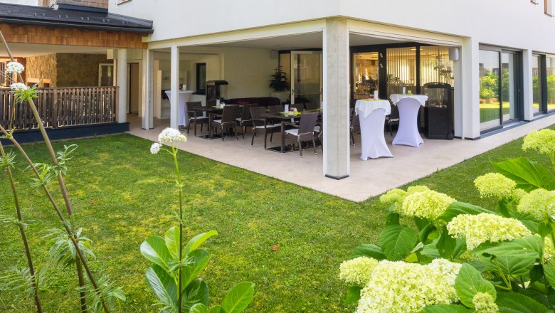 Exterior view of a modern hotel with terrace and garden.