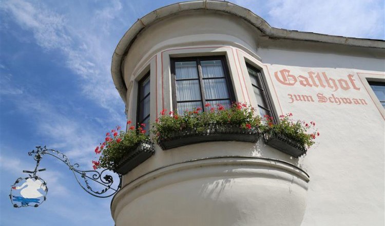 Facade of the Gasthof zum Schwan with bay window and flower boxes.