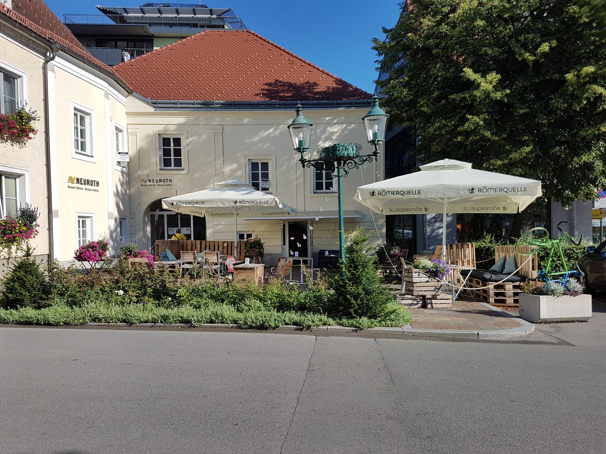 Café from outside, yellow facade 2 sunshades