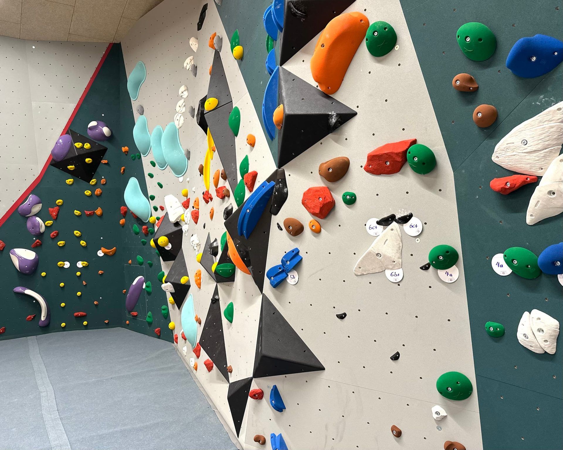Bouldering wall with colorful holds in a climbing gym.