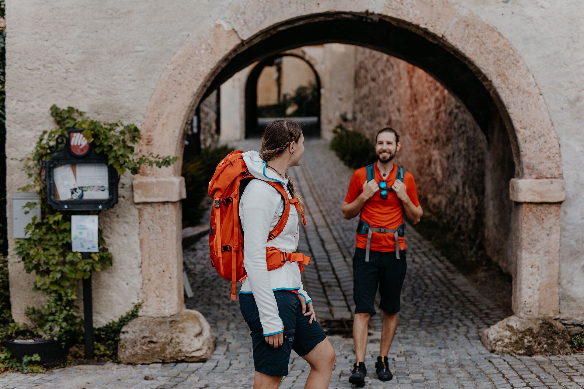 Two hikers stand at the entrance gate to Gloggnitz Castle