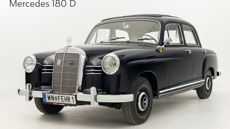 A black Mercedes 180 D vintage car in a studio with a white background.