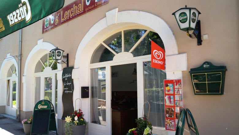 Exterior view of a restaurant with G&ouml;sser signs and Eskimo ice cream advertising.