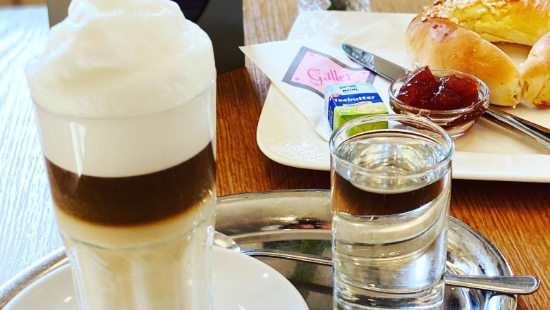 Set breakfast table with latte macchiato and brioche croissants with jam