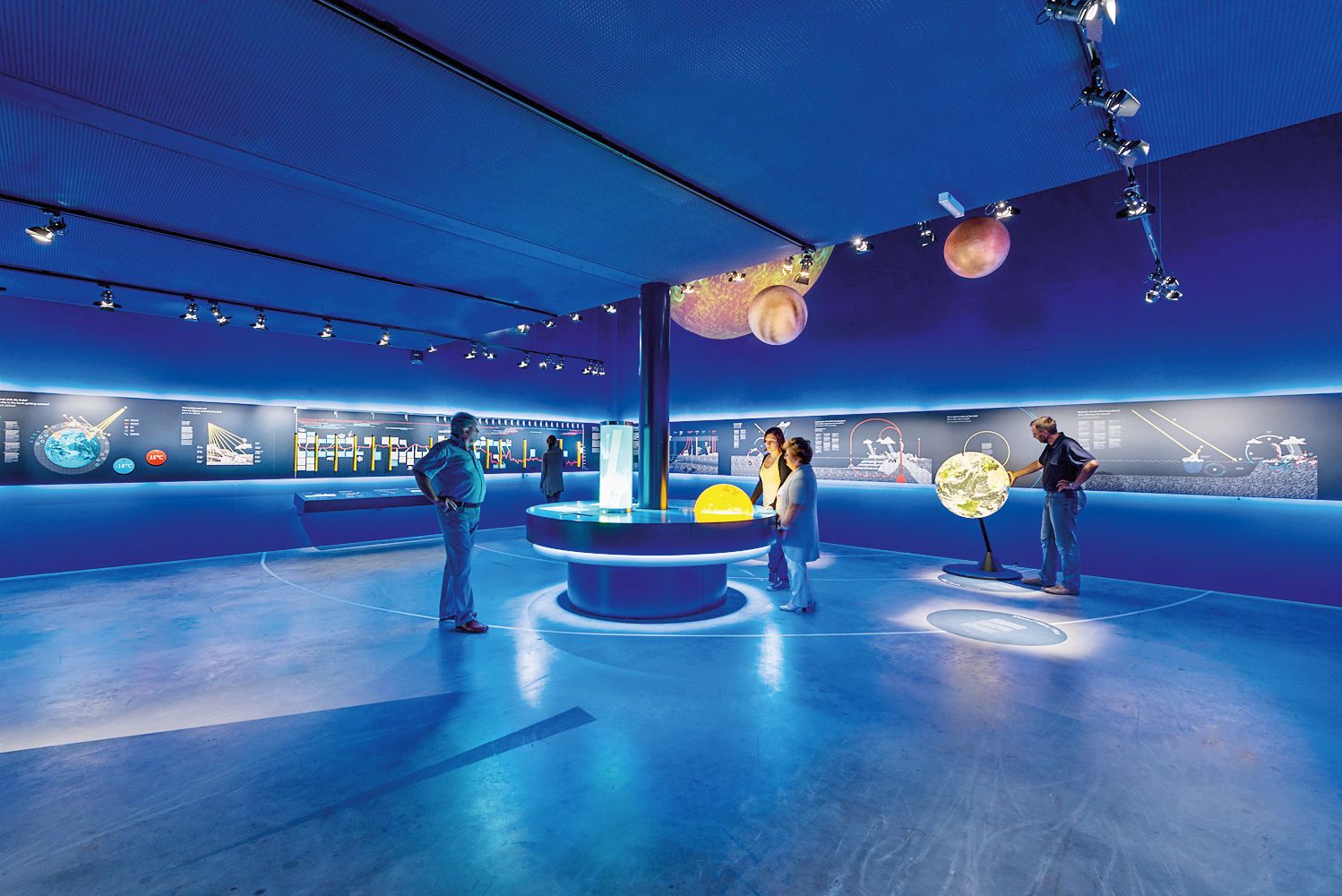 Interior view of the SONNENWELT Großschönau exhibition with blue lighting and interactive exhibits.
