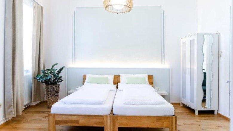 Guest room, © Fam. Willmann Modern guest room with two single beds, a closet and a plant.