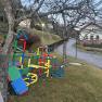Colorful climbing frames on a meadow next to a road in a rural area.