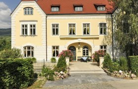 Yellow building with red roof and garden, Josef Jamek winery.