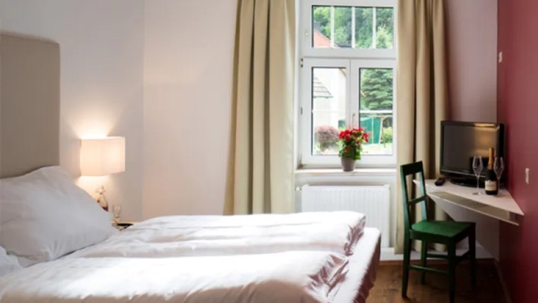 Double bed with window and table corner with TV