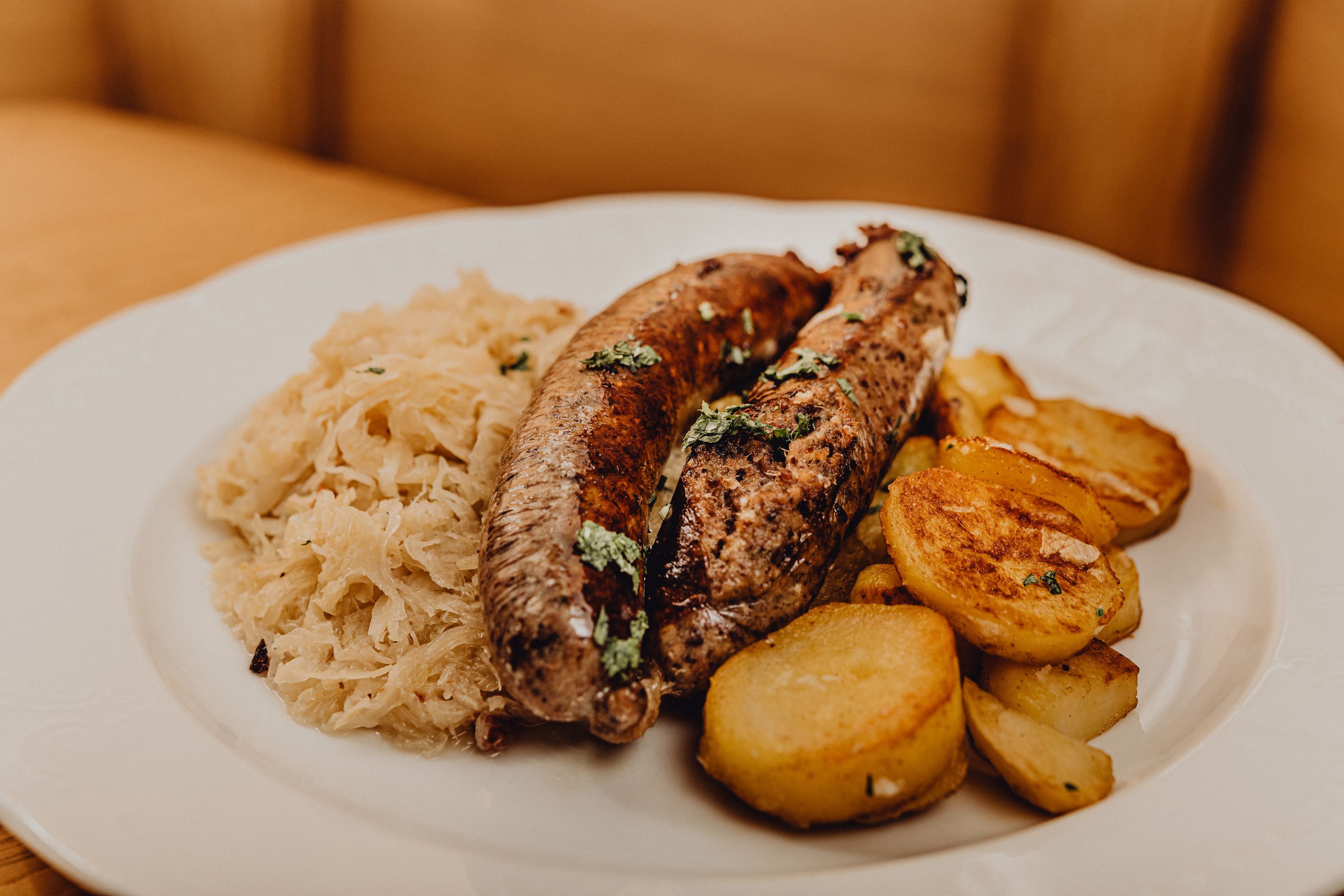 A plate of liver sausage, roast potatoes and sauerkraut.