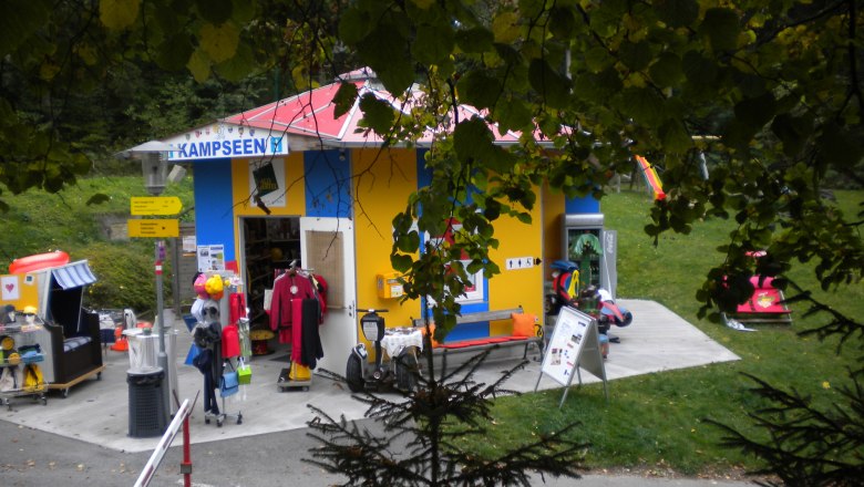 Small, colorful information center with outdoor toys and clothing.
