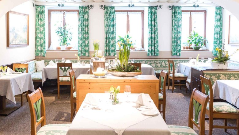 Cozy dining room with wooden furniture and green curtains.