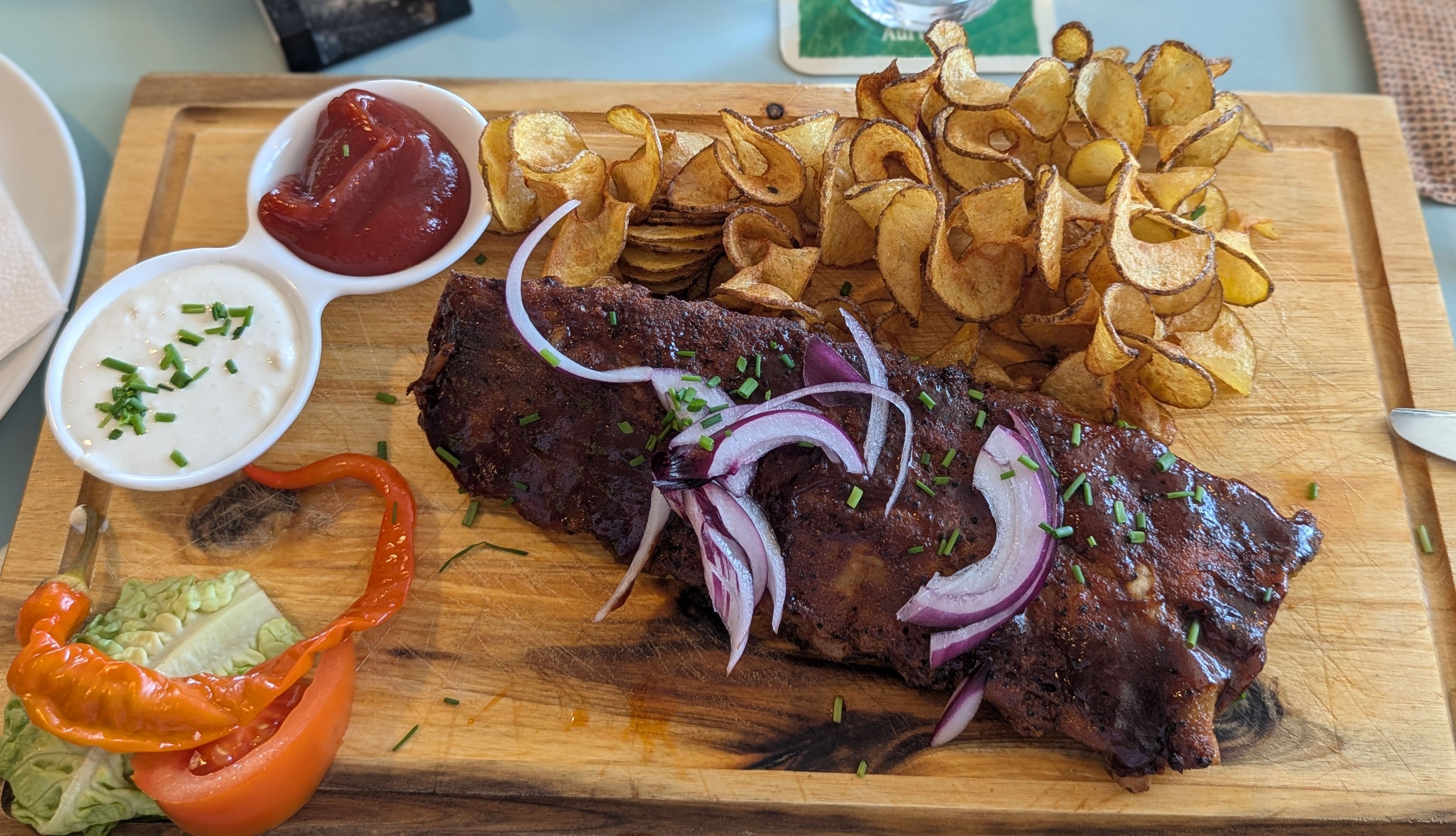 Spareribs and spiral potatoes on a wooden board.