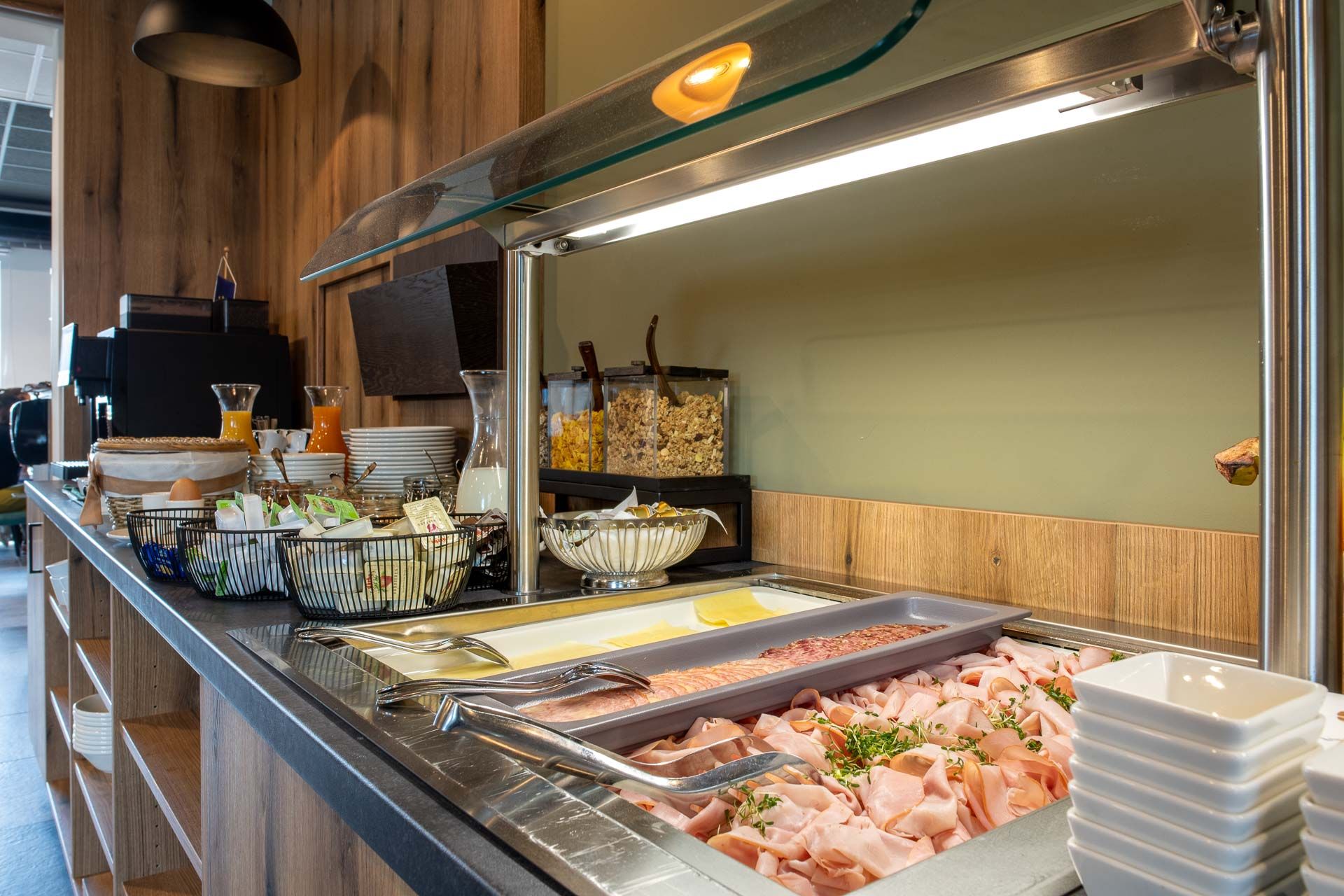 Breakfast buffet with cold cuts, cheese, muesli and drinks.