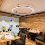 Cozy restaurant with wooden walls, modern lighting and elegantly laid tables.