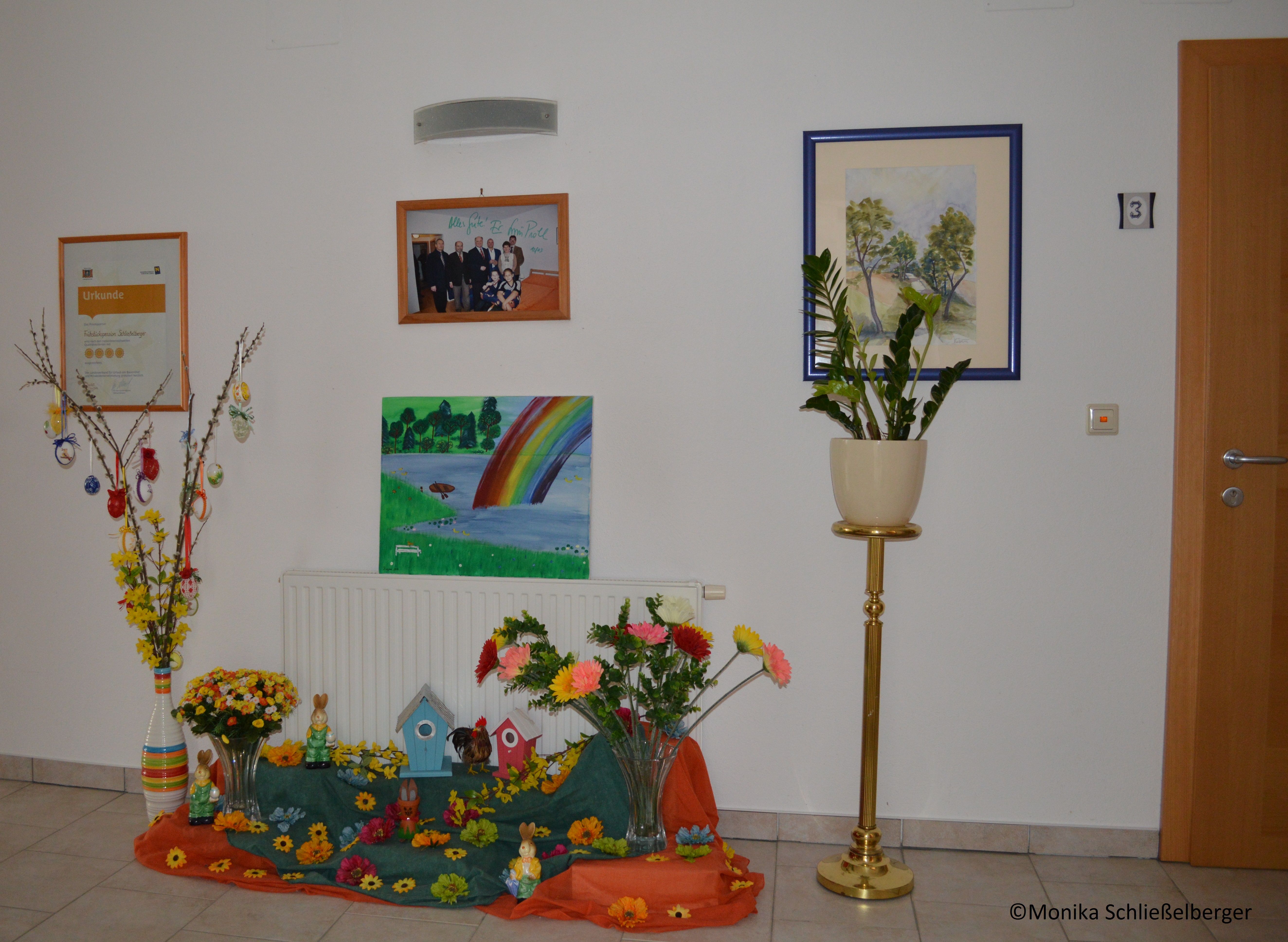 Decorated entrance area with pictures, plants and Easter decorations.
