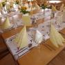Festively laid table in an Alpine inn with yellow napkins and flowers.