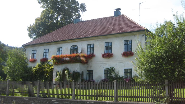 A two-storey house with red roof tiles and flower boxes on the windows.