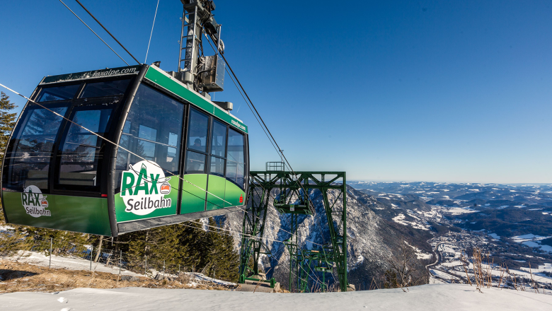 Rax cable car in winter with snow-covered landscape.