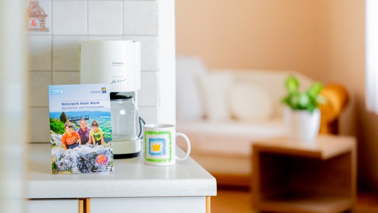 Kitchen worktop with brochure, coffee cup and coffee machine.
