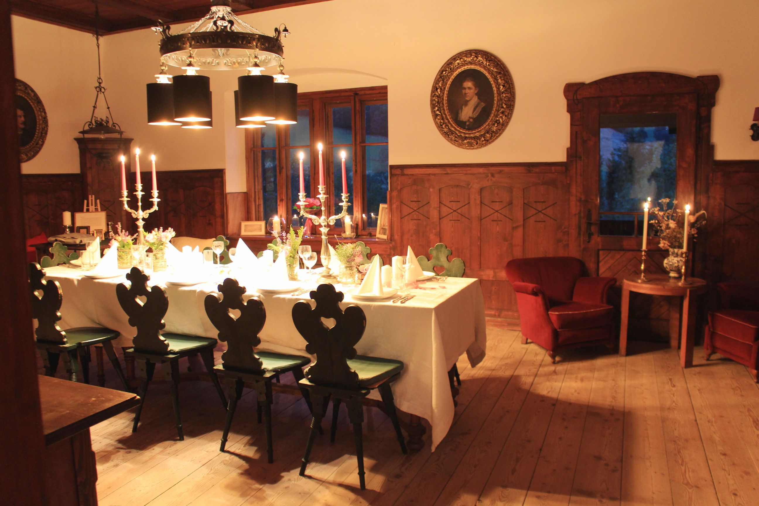 Elegant dining room with table setting, candlesticks and antique furniture.