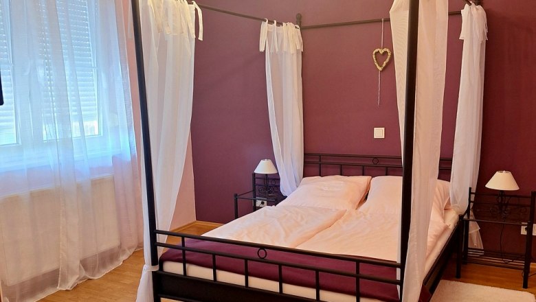 Cozy bedrooms, © Fam. Windisch Bedroom with four-poster bed, purple walls and white curtains.