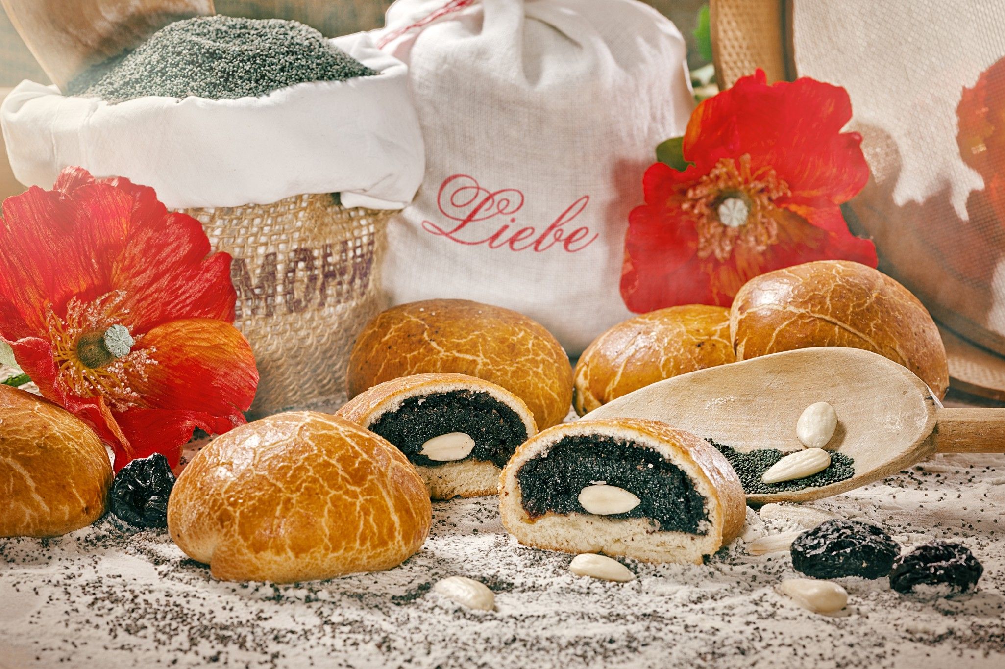 Poppy seed roll decorated with almonds, poppy seeds and red flowers.