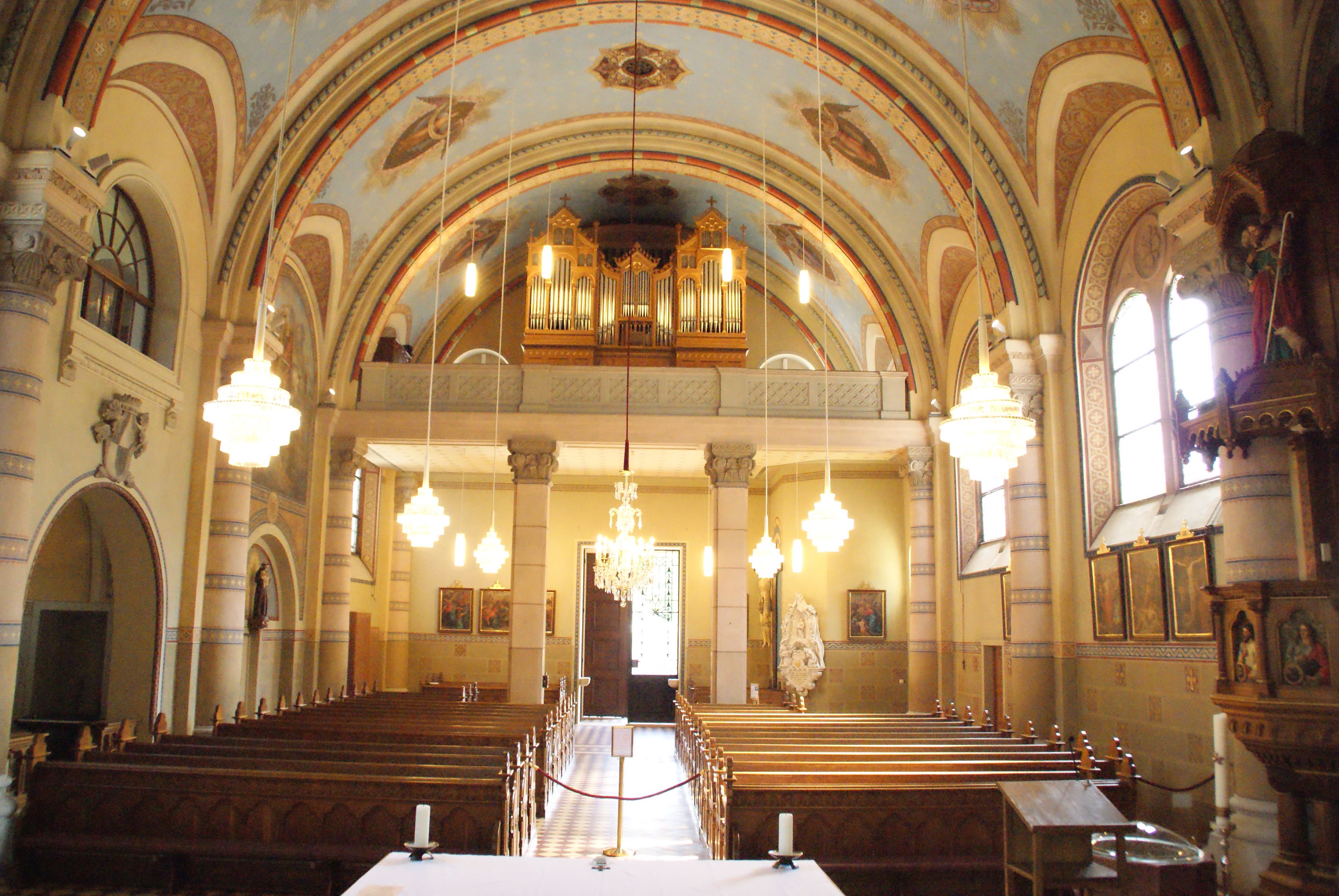 Interior view of the parish church of St. Martin with pews, organ and chandeliers.