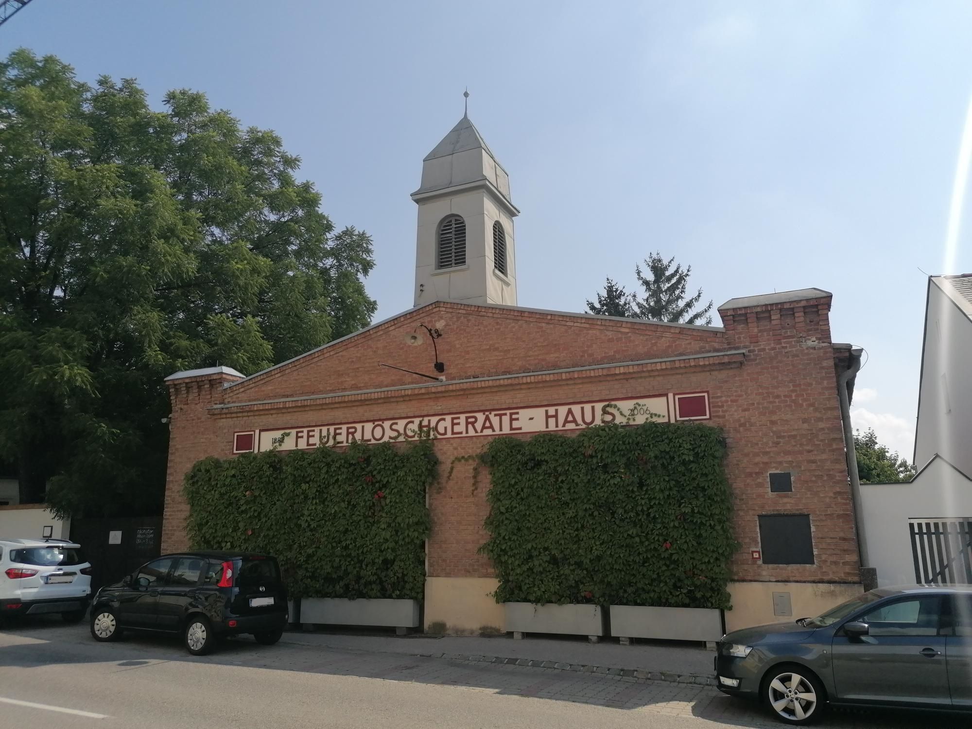 Old fire station in Bad Fischau with brick façade and tower.