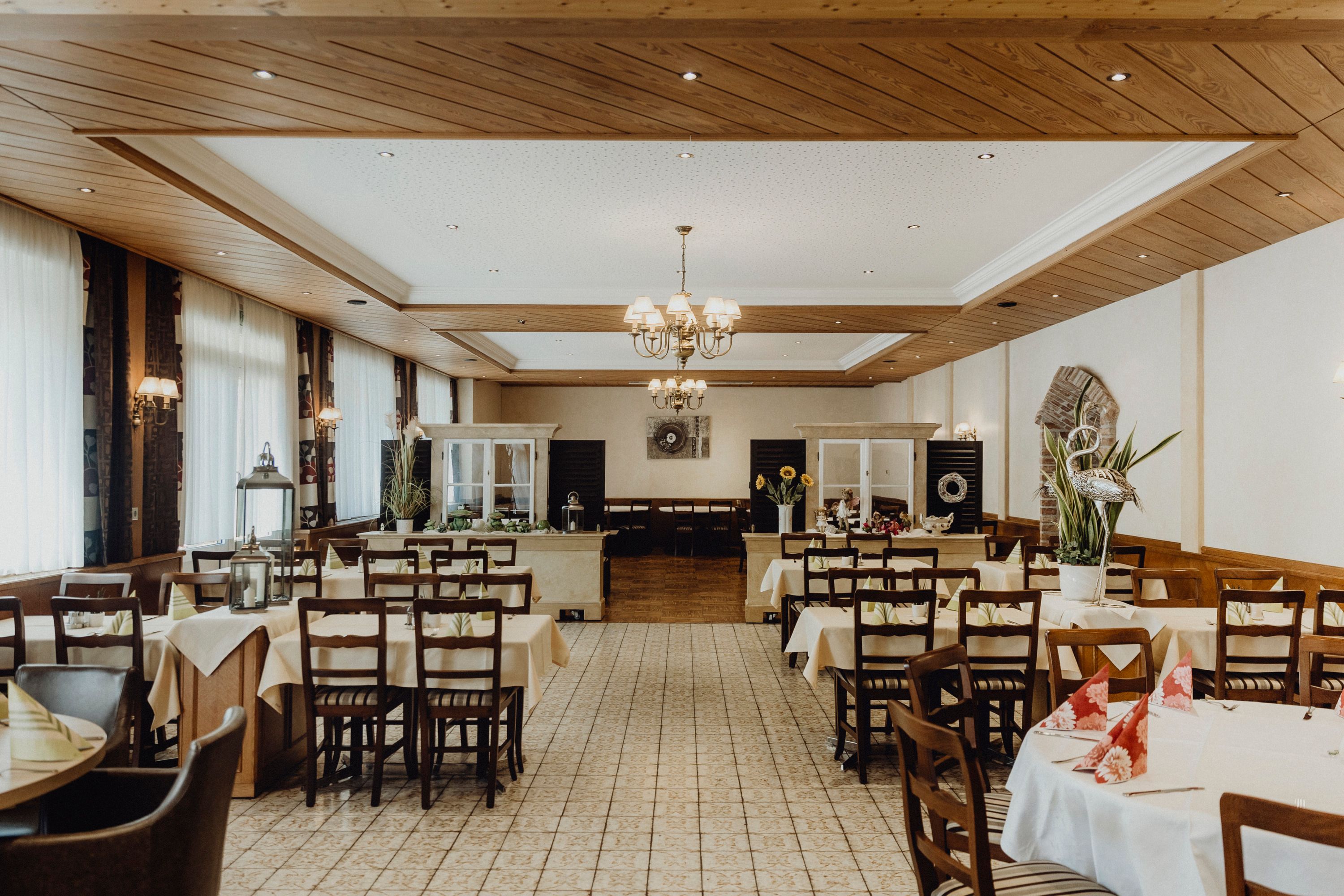 Interior view of a traditional inn with covered tables and wooden ceiling.
