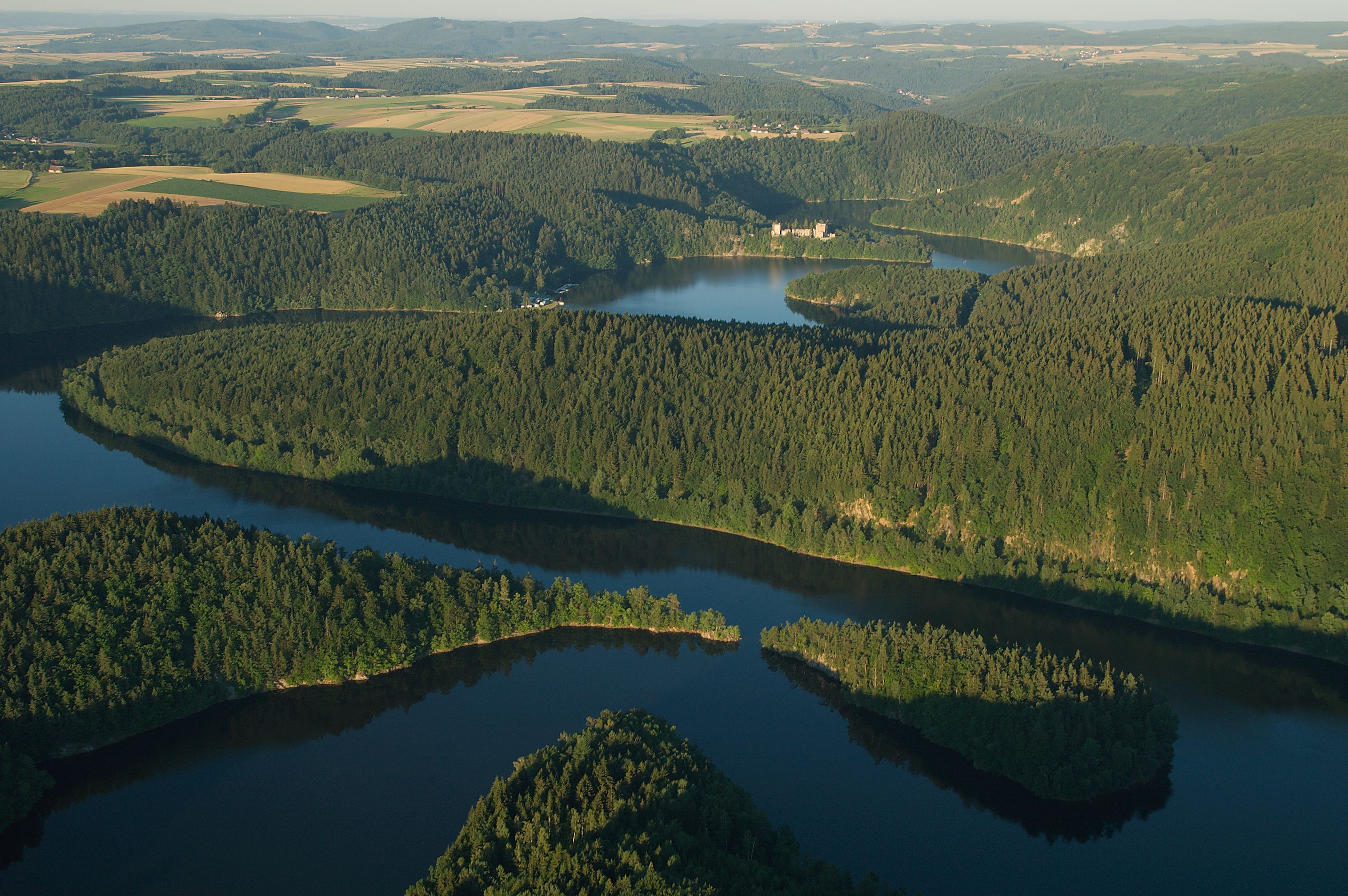 Aerial view of the Dobra reservoir with surrounding forests and hills.