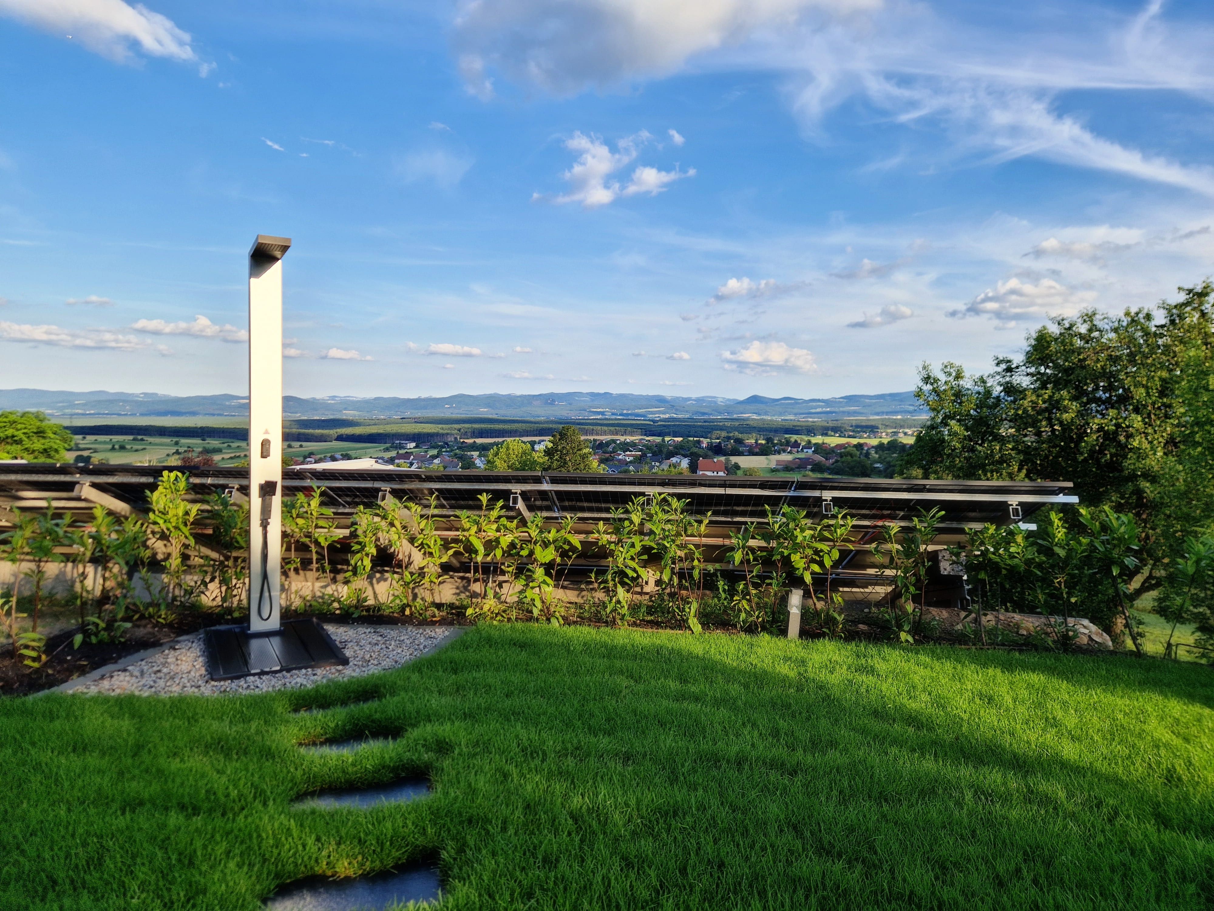 Solar shower in the garden with views of the countryside and blue sky.