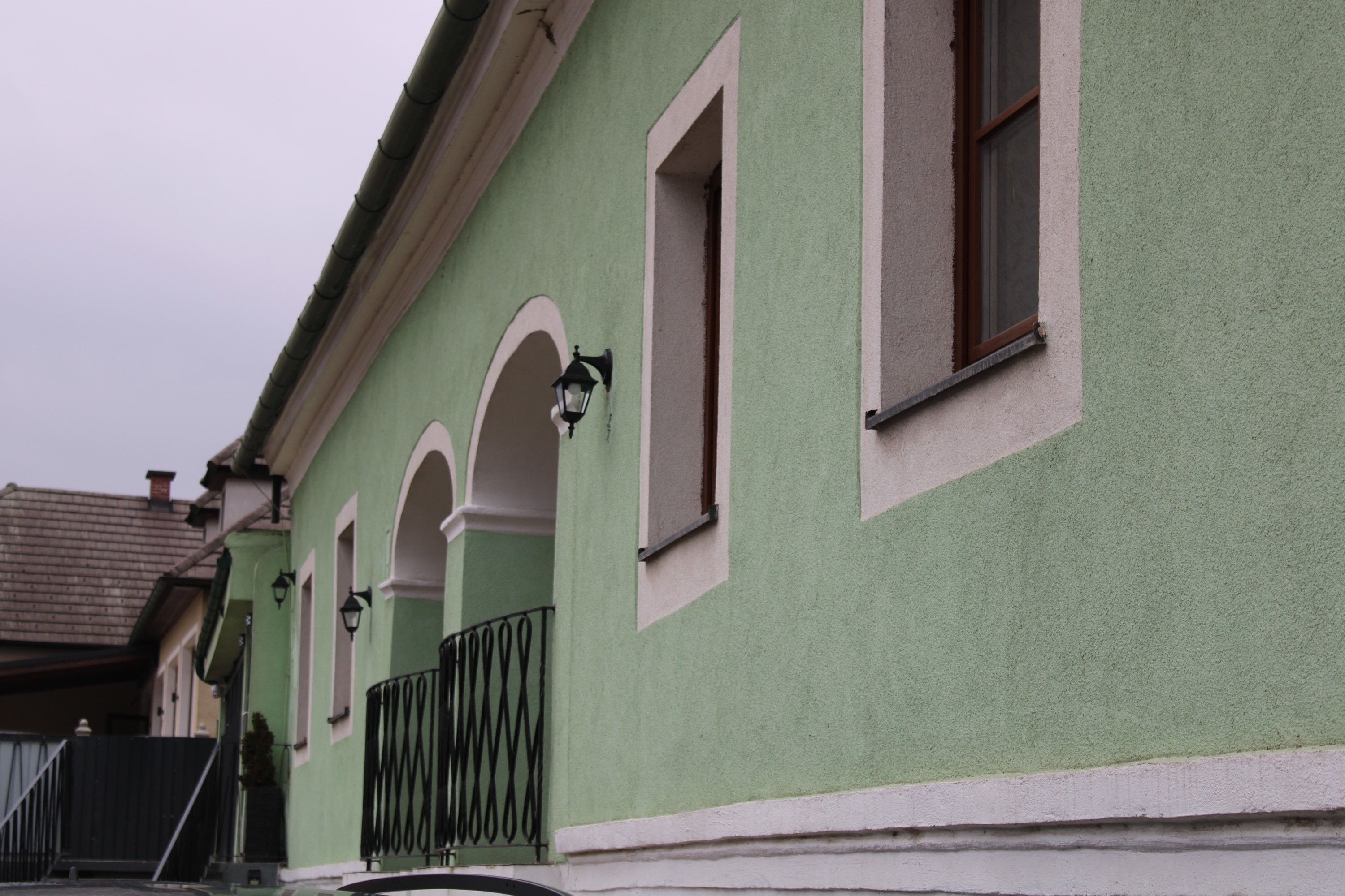 Green building with white window frames and lanterns.
