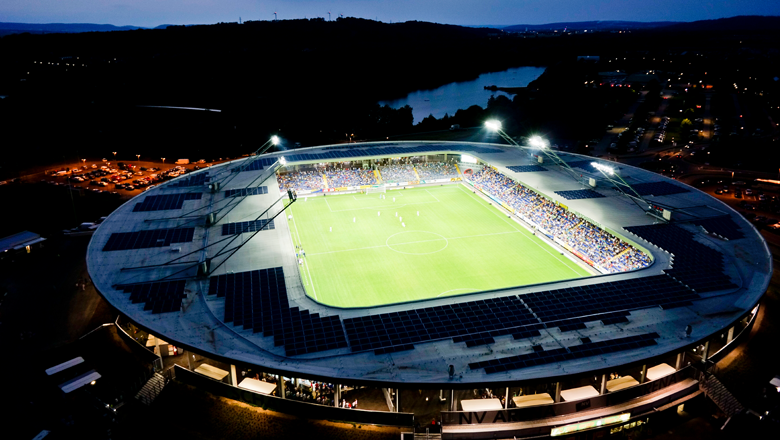 Aerial view of an illuminated soccer stadium at night.