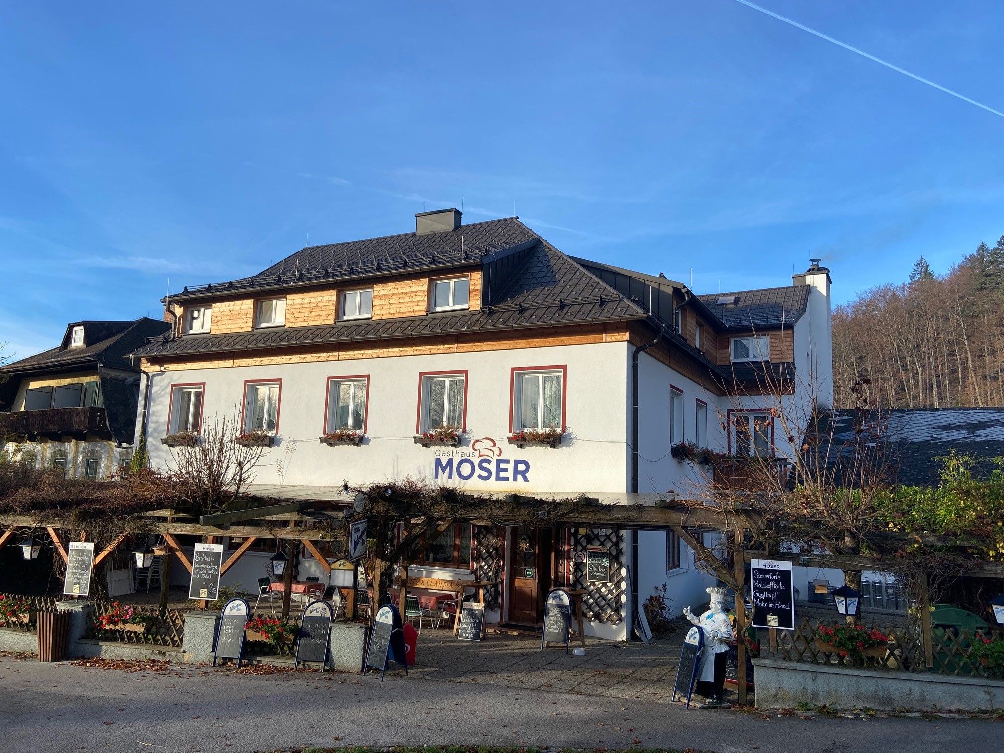 Gasthaus Moser with terrace and blue sky in the background.