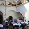 Inner courtyard of an inn with laid tables and flowers.