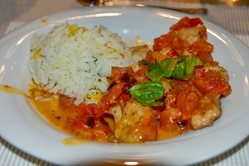 A plate of carp fillet with tomato and basil ragout and basmati rice.