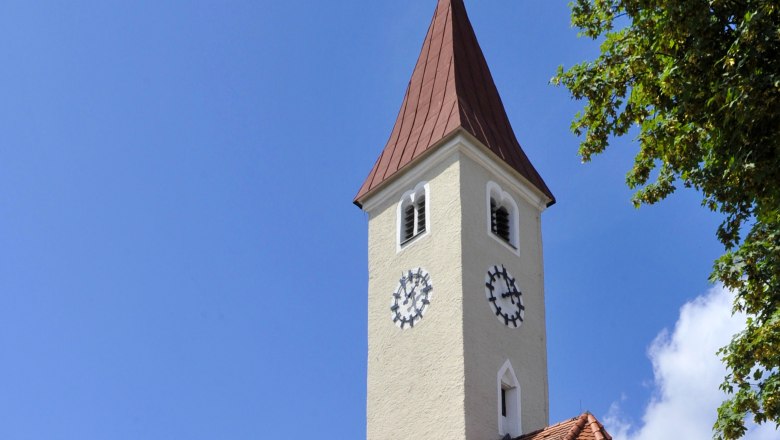 Allentsgschwendt parish church with tower and clock against a blue sky.