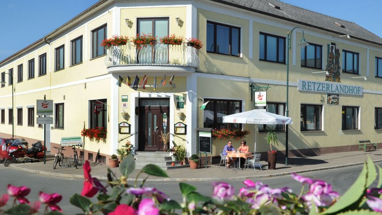 Exterior view of the Retzerlandhof with terrace and flowers.