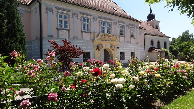 Baroque building with rose garden in the foreground.