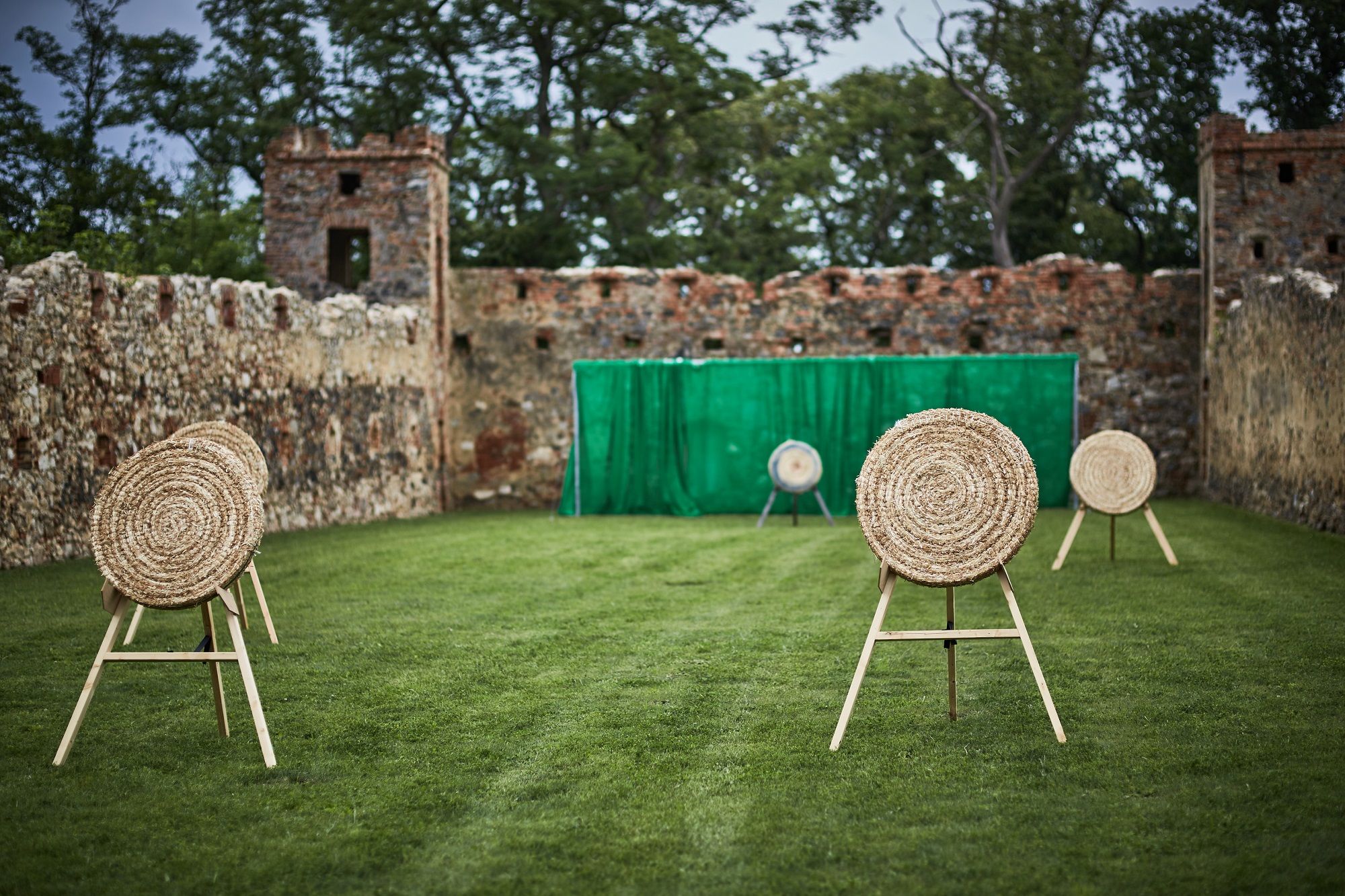 Archery range with targets in front of an old stone wall.