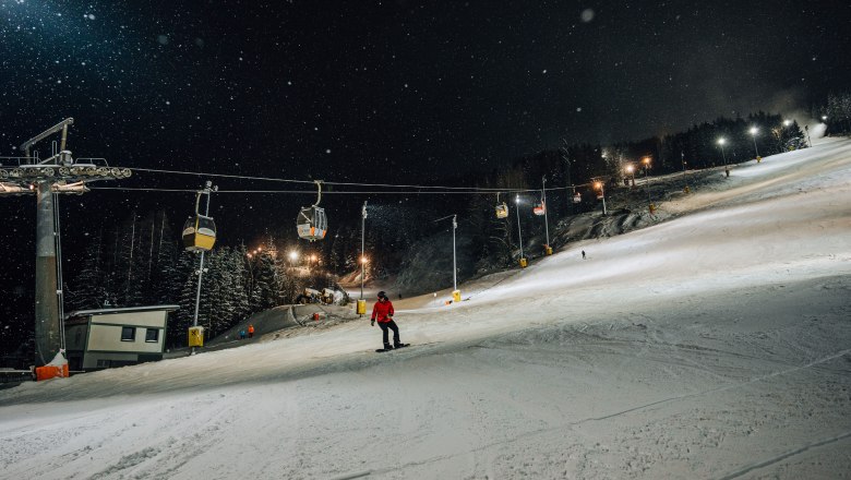 Night skiing on the Semmering Hirschenkogel with floodlit piste and ski lift.