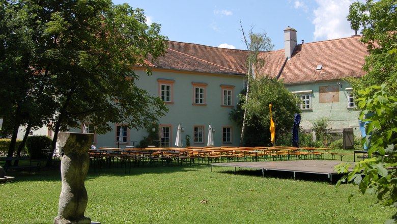 Bad Fischau Castle with garden and beer tables.