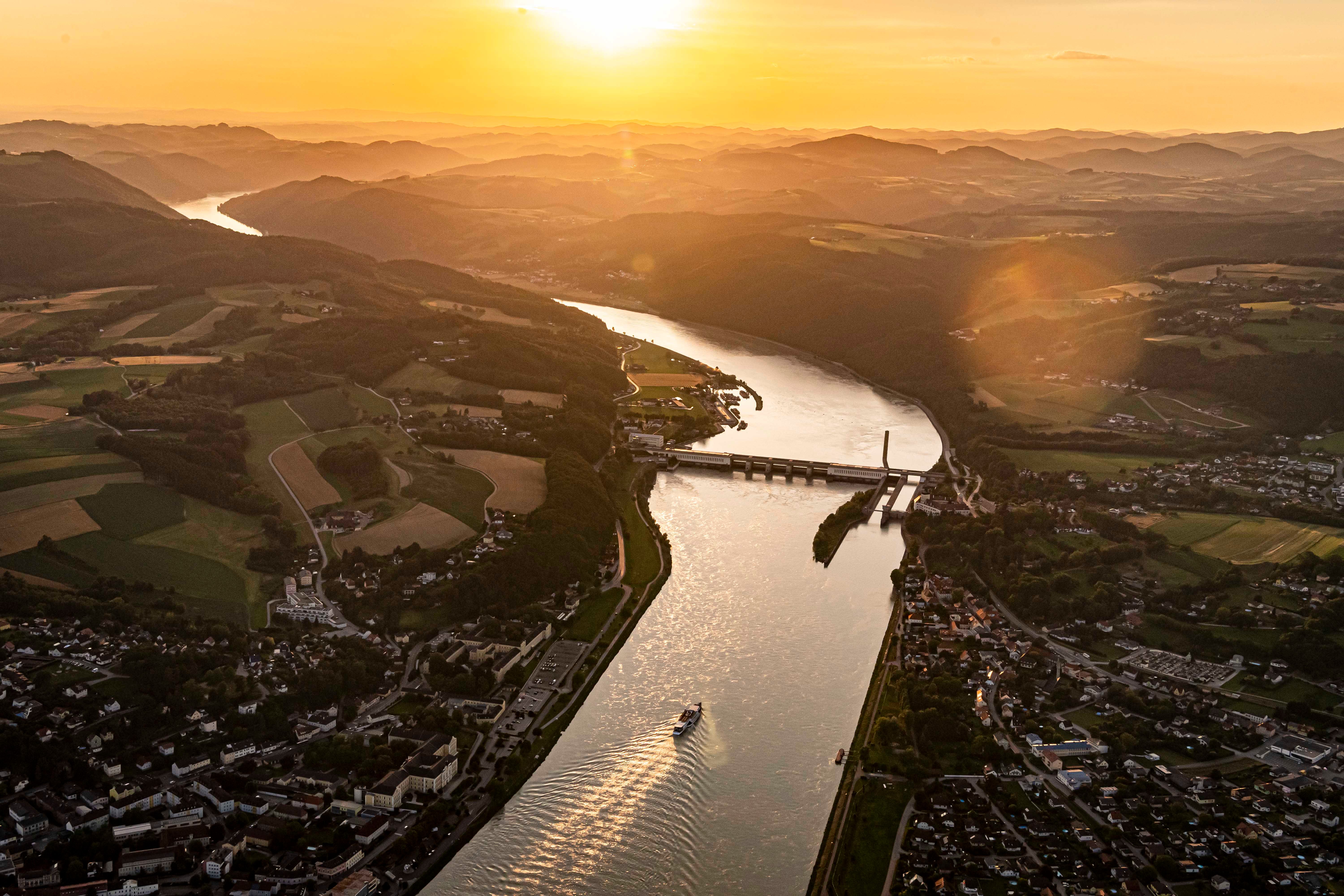 Aerial view of a river with a power station at sunset.