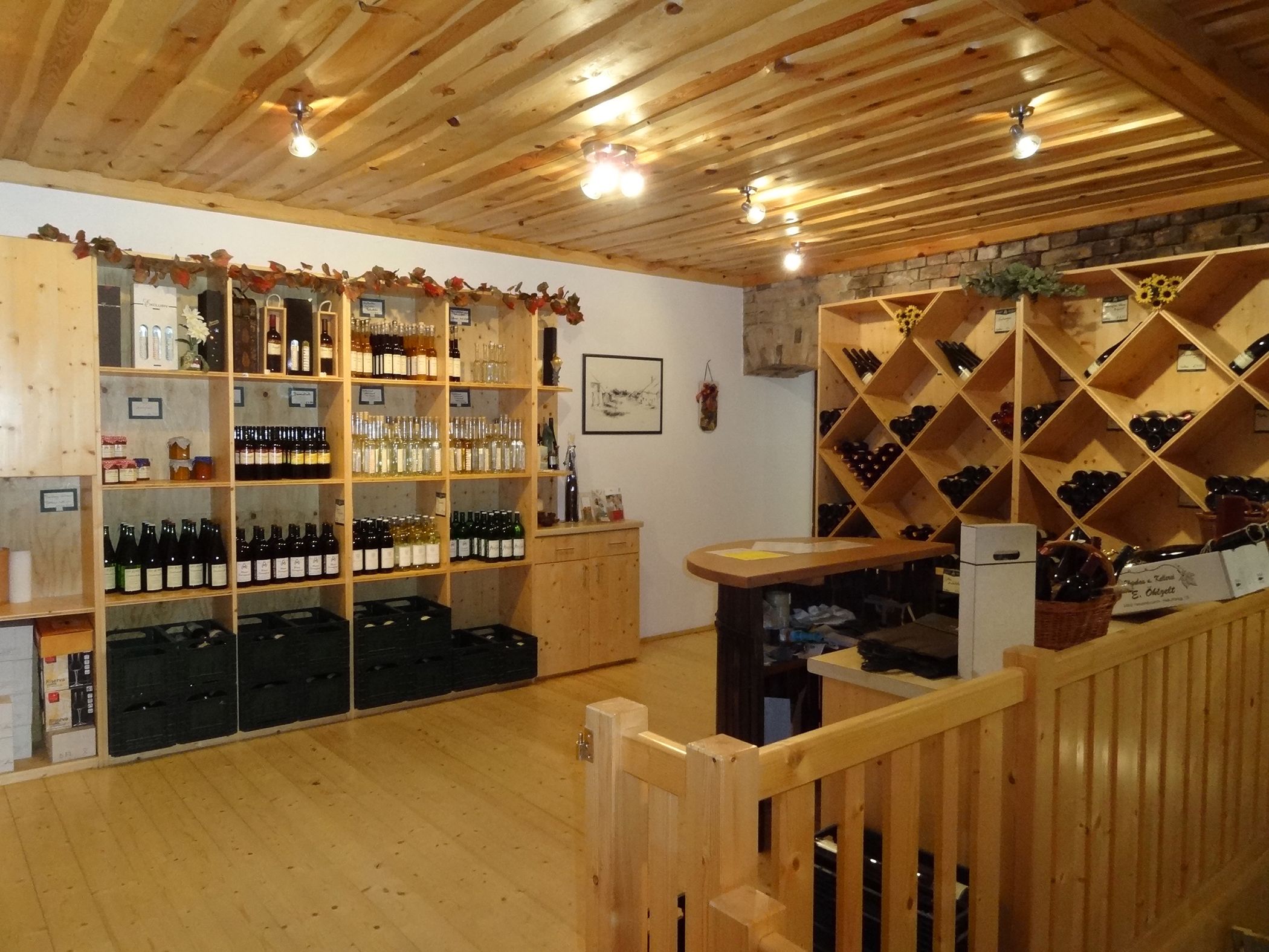 Interior view of a wine shop with wooden shelves full of wine bottles and spirits.