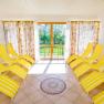 Bright sauna area with yellow and white striped loungers and large windows.