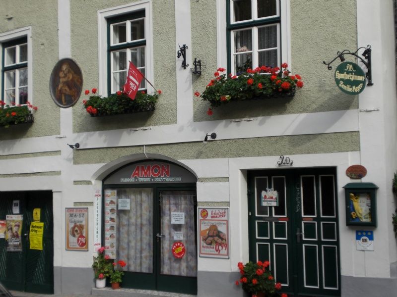 Exterior view of a building with flowers and signs.