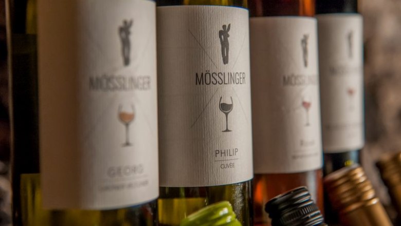 Close-up of wine bottles with M&ouml;sslinger brand labels.