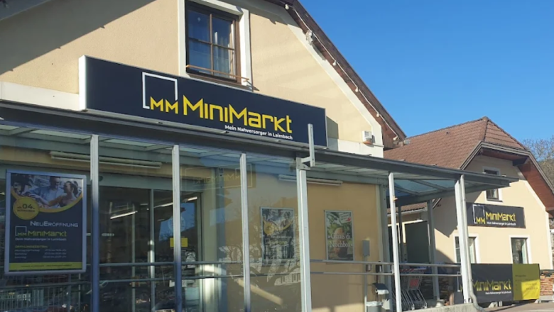 Exterior view of a MiniMarkt store with glass façade and advertising posters.