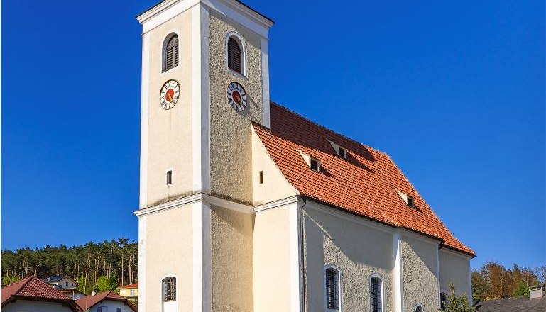 Hollenthon parish church with onion dome and blue sky.